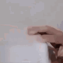 a person is holding a white box in their hand .