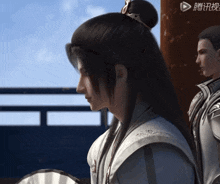 a man with a bun on his head stands next to another man with a fan
