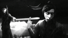 a black and white image of a man holding a sword