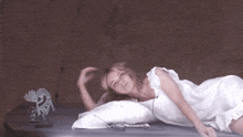 a woman in a white dress is laying on a bed next to a coyote statue