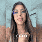 a woman wearing glasses has the word cero written on her hand