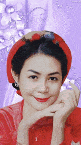 a woman wearing a red hat and earrings is smiling with her hand on her chin