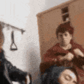 a blurry picture of a woman sitting in front of a mirror with a man standing behind her .