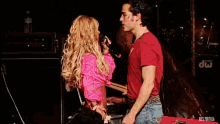 a man and a woman on a stage with drums in the background