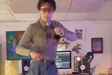 a man is singing into a microphone in front of a computer monitor