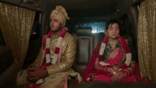 a bride and groom sitting in the back seat of a car