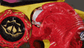 a close up of a red and yellow toy with a coin inside of it .