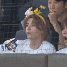 a woman wearing a headband with a pikachu on it watches a game
