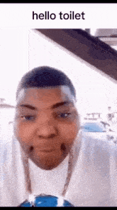 a man is making a funny face in a car with the words `` hello toilet '' on the bottom .