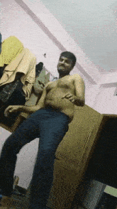 a shirtless man dancing in a room with clothes hanging on the wall