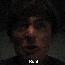 a close up of a man screaming with the word run written in the corner