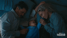 a man and a woman laying next to a baby with fantastic 4 written on the bottom left