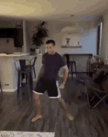a man is dancing in a living room in a living room .