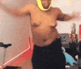 a shirtless man with a yellow headband on his head is dancing