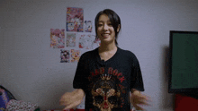 a woman wearing a hard rock t-shirt is smiling