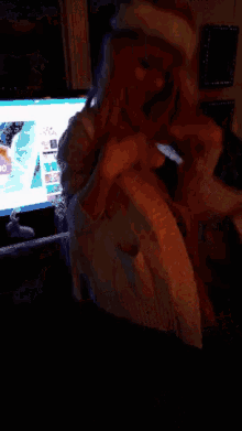a woman wearing a santa hat is dancing in a room