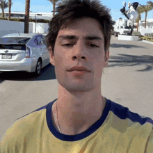 a man in a yellow shirt has a california license plate that says srswd