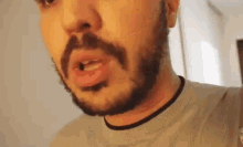 a close up of a man 's face with a beard .