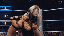 two women are wrestling in a wrestling ring with the word win on the screen
