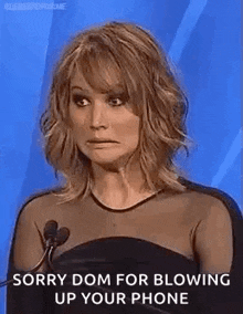 a woman is standing in front of a microphone and making a face .