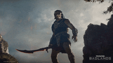 a poster for predator badlands shows a warrior holding a sword