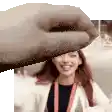 a hand is holding a woman 's head in front of a camera .