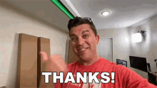 a man in a red shirt is giving a thumbs up and saying thanks !