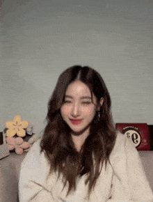 a woman in a white sweater with the letter e on her chest