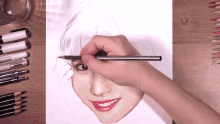 a person is drawing a picture of a woman 's face with a pencil