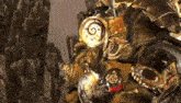 a statue of a robot with a clock on it is sitting on top of a mountain .