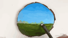 a person is painting a landscape on a piece of wood with a brush