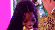 a woman is smiling while standing next to a man .