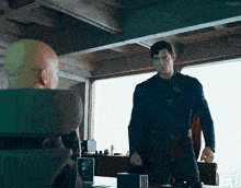 a man in a superman costume talks to another man in a chair