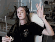 a woman wearing headphones and a black t-shirt with a cat on the front
