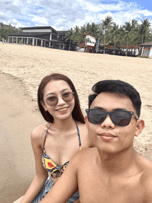 a man and a woman are posing for a picture at the beach