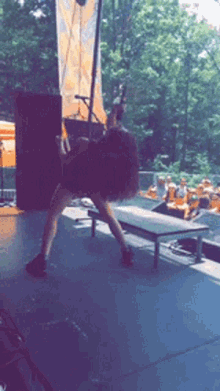 a woman dancing on a stage with a microphone in the background