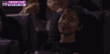 a woman is smiling while sitting in a movie theater .