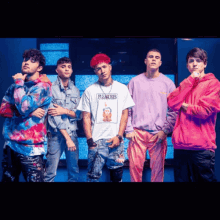 a group of young men are posing for a photo and one of them is wearing a pleasures shirt