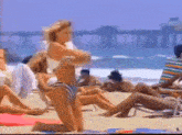 a woman in a bikini kneeling on the beach
