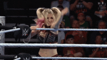 a woman in a wrestling ring with a w logo on her glove