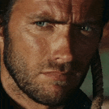 a close up of a man 's face with a beard