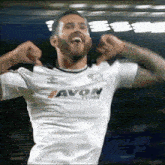 a man wearing a white shirt that says avon tyres