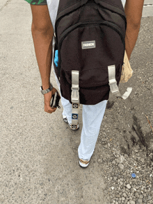 a man wearing a black backpack that says fashion on it