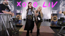 a man and a woman are standing in front of a sign that says " xoxo liv "
