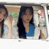two women are sitting in a car with a vw park off sign on the window .