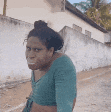 a woman in a blue top is making a face