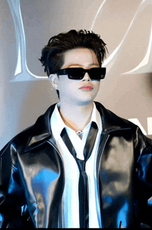 a man wearing sunglasses and a leather jacket