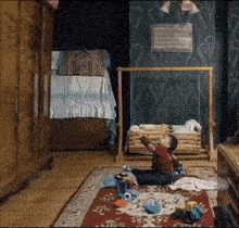 a little boy is sitting on a rug in a room with a crib .