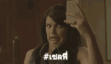 a woman is taking a selfie in front of a mirror .