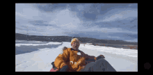 a person wearing a jacket that says dad is riding a sled in the snow
